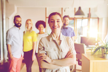 happy young woman over creative team in office