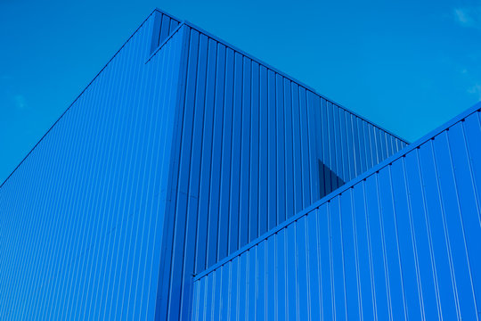 Modernes Gebäude aus blauem Trapezblech vor blauem Himmel - Contemporary building in blue trapezoidal sheet against blue sky