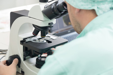 Scientific researcher in the laboratory with a microscope