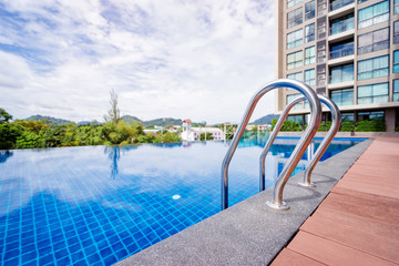 Outdoor infinity swimming pool in condo building - obrazy, fototapety, plakaty
