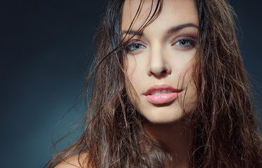 Fototapeta premium Sexy beauty. Close-up studio portrait of young fashion model with beautiful blue eyes looking at camera.