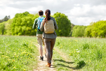 Fototapeta na wymiar happy couple with backpacks hiking outdoors