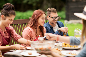 happy friends having dinner at summer garden party