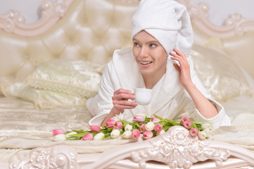 Obraz na płótnie Canvas woman wearing a white bathrobe with tea