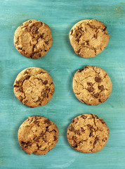 Two rows of chocolate chips cookies, on teal