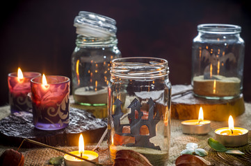 Fototapeta na wymiar kompozycja halloween ze świecami słoikami na stole, Don't open till Halloween