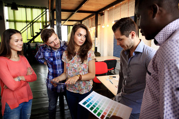 Portrait of happy young people in a meeting looking at camera and smiling. Young designers working together on a creative project