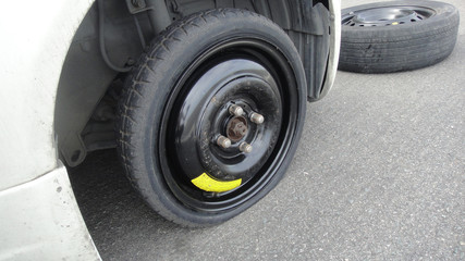 Car flat spare wheel on highway
