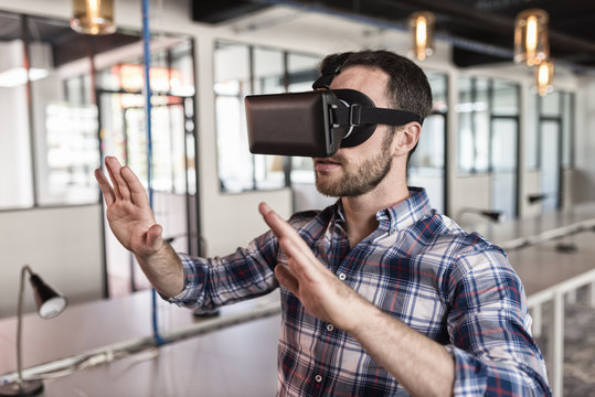 Man using virtual reality glasses in startup office.