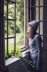 Woman look at the window in an abandoned house  - 122844835