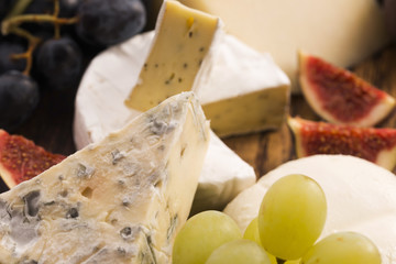 Assortment of cheese with fruits and grapes