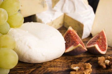 Assortment of cheese with fruits and grapes