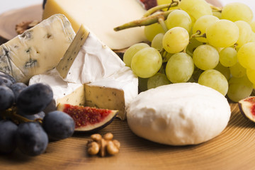 Assortment of cheese with fruits and grapes