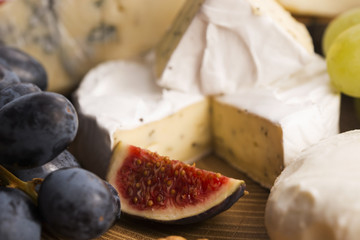 Assortment of cheese with fruits and grapes