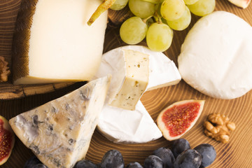 Assortment of cheese with fruits and grapes