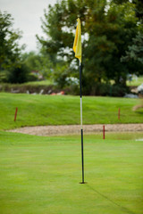 Obraz premium Golf course detail with the yellow flag in front