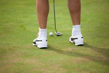 Golf ball and stick with golfer legs