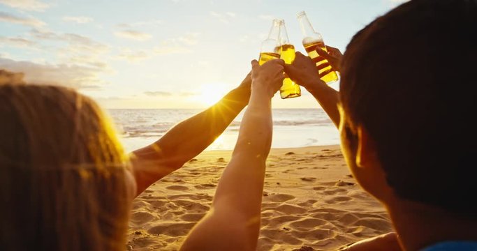 Group of friends enjoying a beverage on the beach at sunset, Cheers!