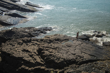 Man standing on the stone cliffs in the Arabian Sea