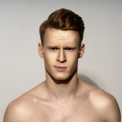 Obraz premium Studio fashion style portrait of young calm handsome red hair man. Closeup face portrait on gray background