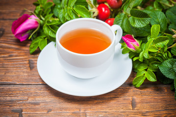 Healthy tea with a dogrose on wooden table