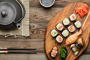 Delicious served sashimi and rolls on wooden background