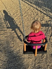 bambina in altalena e la sua ombra