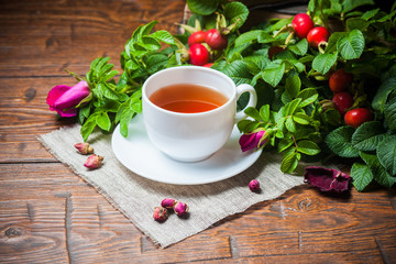 Fototapeta na wymiar Healthy tea with a dogrose on wooden table