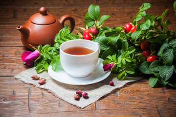 Healthy tea with a dogrose on wooden table