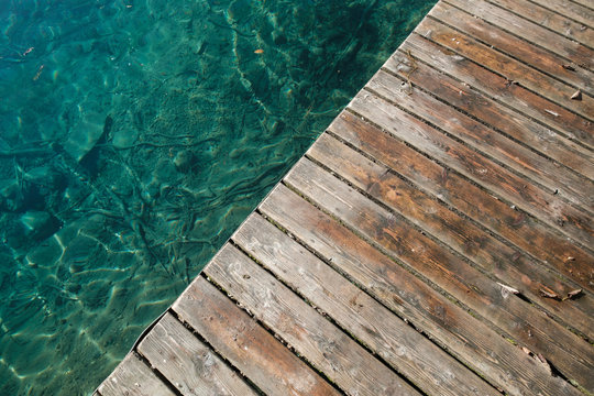 Fototapeta Wooden pier at a lake in the alps