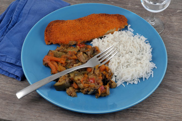 Assiette avec du poisson pané avec du riz et une ratatouille de légumes