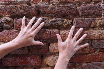 hand on an old brick wall
