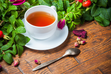 Healthy tea with a dogrose on wooden table