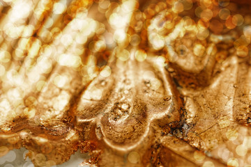 Close up of grunge golden potal texture. Foil on architectural detail. Cracelures and bitumen varnish. Selective macro focus.