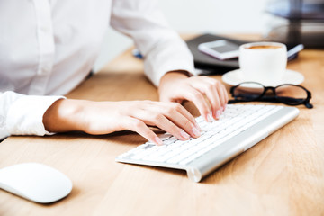 Cropped image of women's hands typing on keyboard