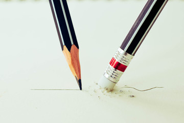 Close up of a pencil eraser removing a crooked line and the clos