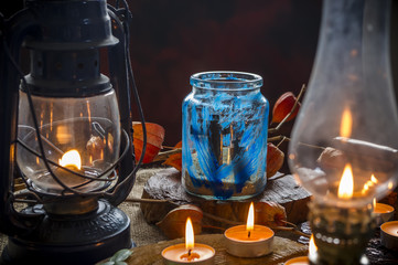 Fototapeta na wymiar straszny halloween kompozycja z świec lamp drzewa słoików zniczy i lampionów, Scary halloween