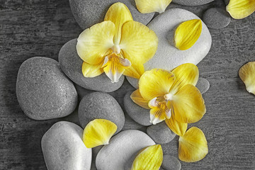 Fototapeta na wymiar Spa stones with orchid flowers, top view