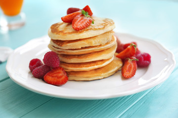 Tasty pancakes with berries on plate