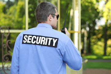 Male security guard near glass building facade