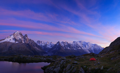 Red tent in the mountains near Chamonix, France, during a colorful sunset.