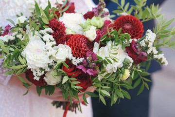 beautiful bouquet of different colors in the hands of the bride in a white dress

