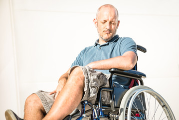 Disabled man with handicap on wheelchair in depression moment - Disability concept with powerless unhelped person sitting alone on wheel chair - Social issues with invalid guy on difficulties
