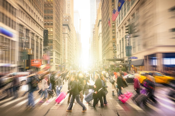 People walking on 7 th av. and West 34 th crossroad in Manhattan before sunset - Crowded streets of New York City on rush hour in urban business area - Radial blur composition with focus on background