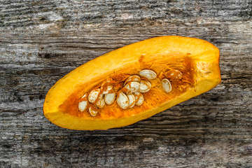 Cut pumpkin slice on wooden background, top view