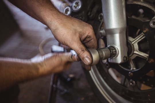 Mechanic examining a motorbike disc brake