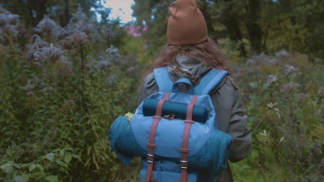 TRACKING FOLLOW Active healthy Caucasian woman with a backpack hiking in autumn forest. 4K UHD RAW edited footage