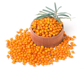 Sea-buckthorn berries in a wooden bowl with leaves isolated on white background