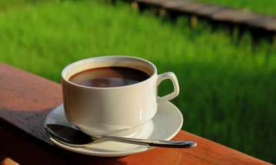 black coffee on wooden table with nature background