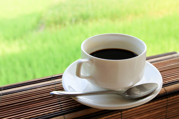 black coffee on wooden table with nature background